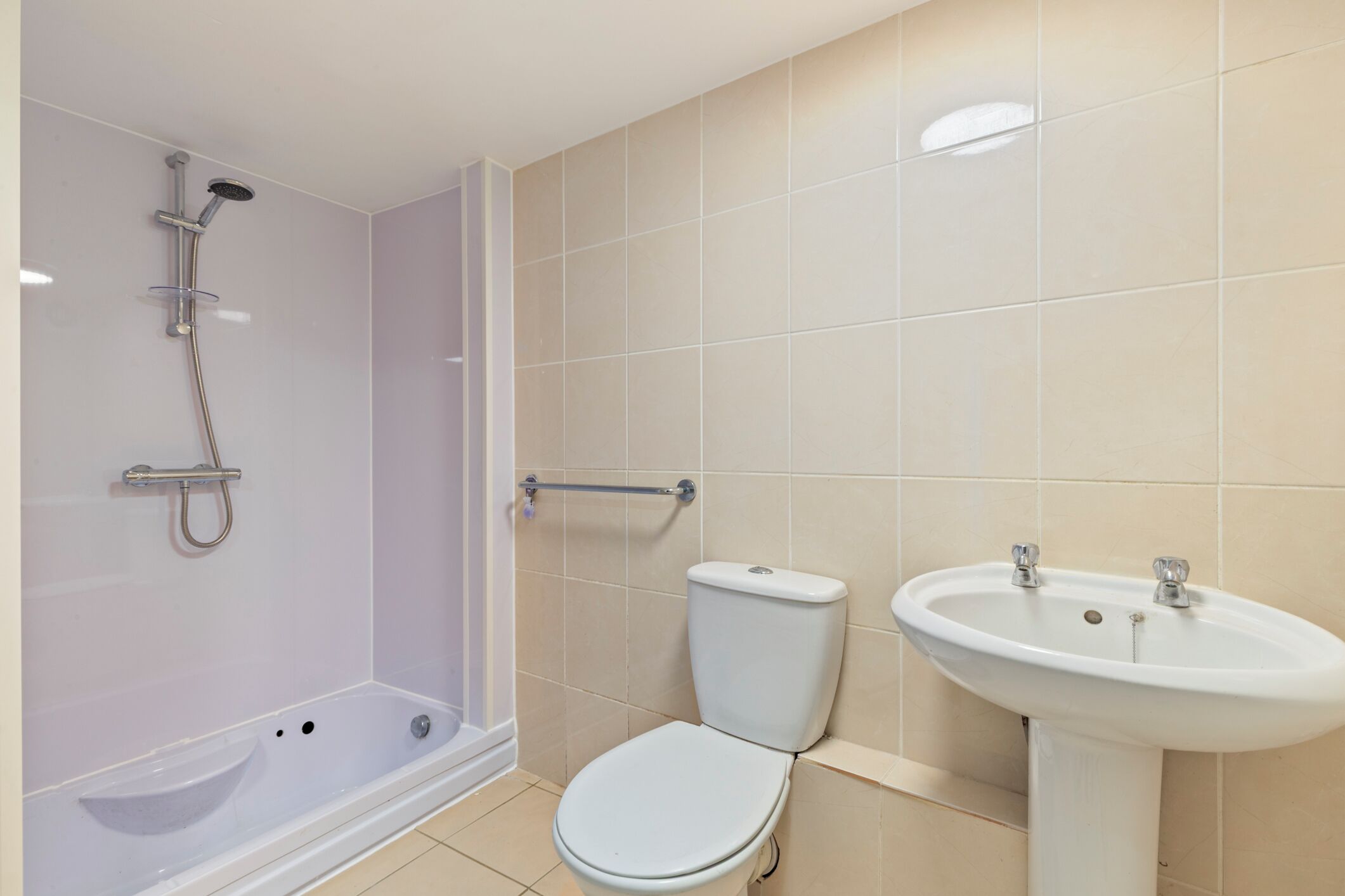 A bathroom with a shower, toilet, and sink.