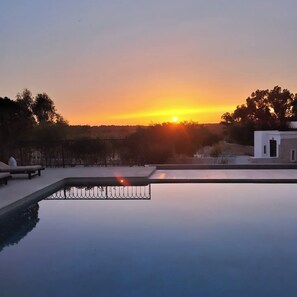 Klarer Himmel bei Sonnenuntergang, mit einem Pool, der den Himmel spiegelt.