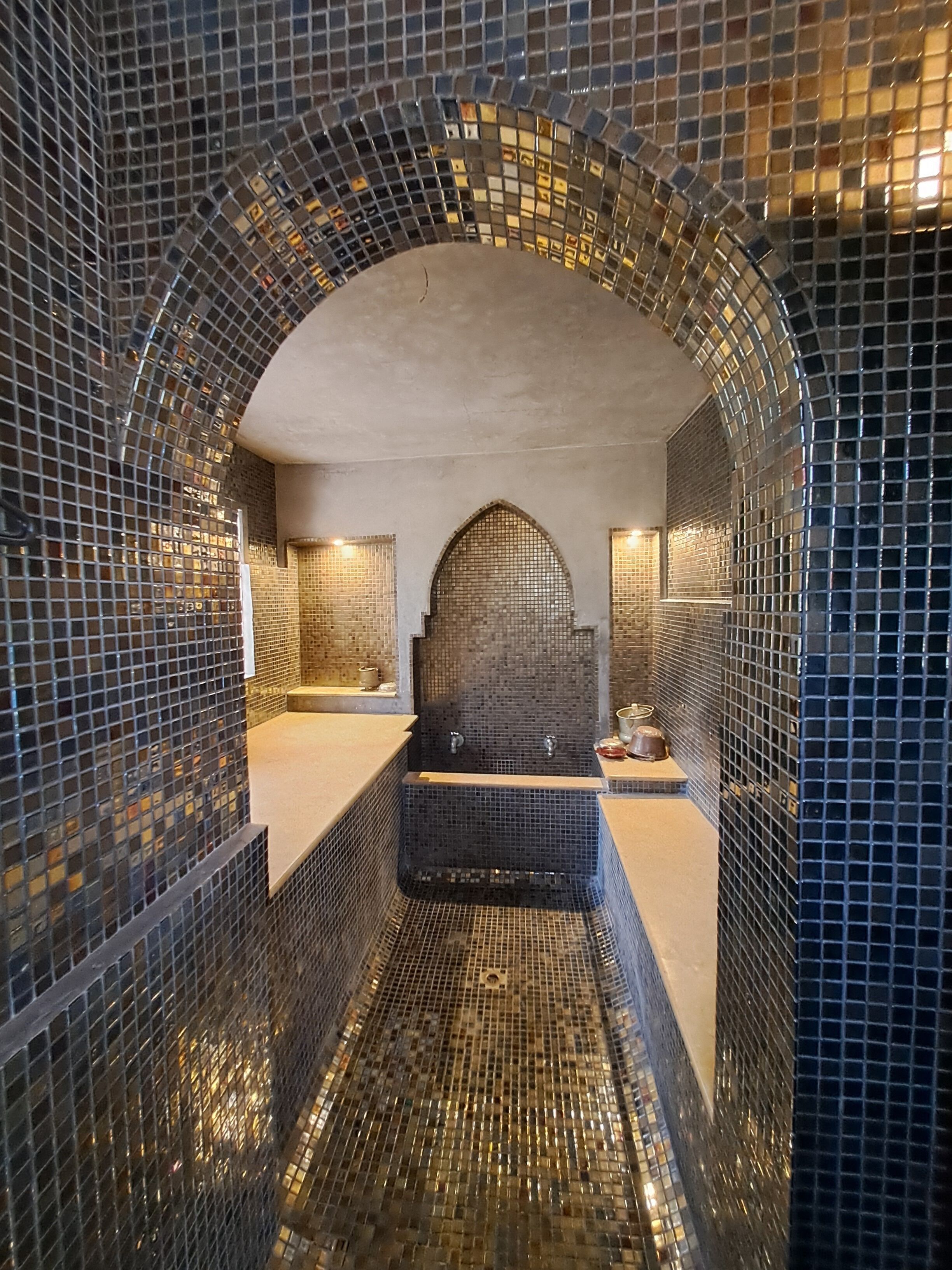 Ein Badezimmer mit Mosaikfliesen, einer Badewanne und einer Duschkabine.