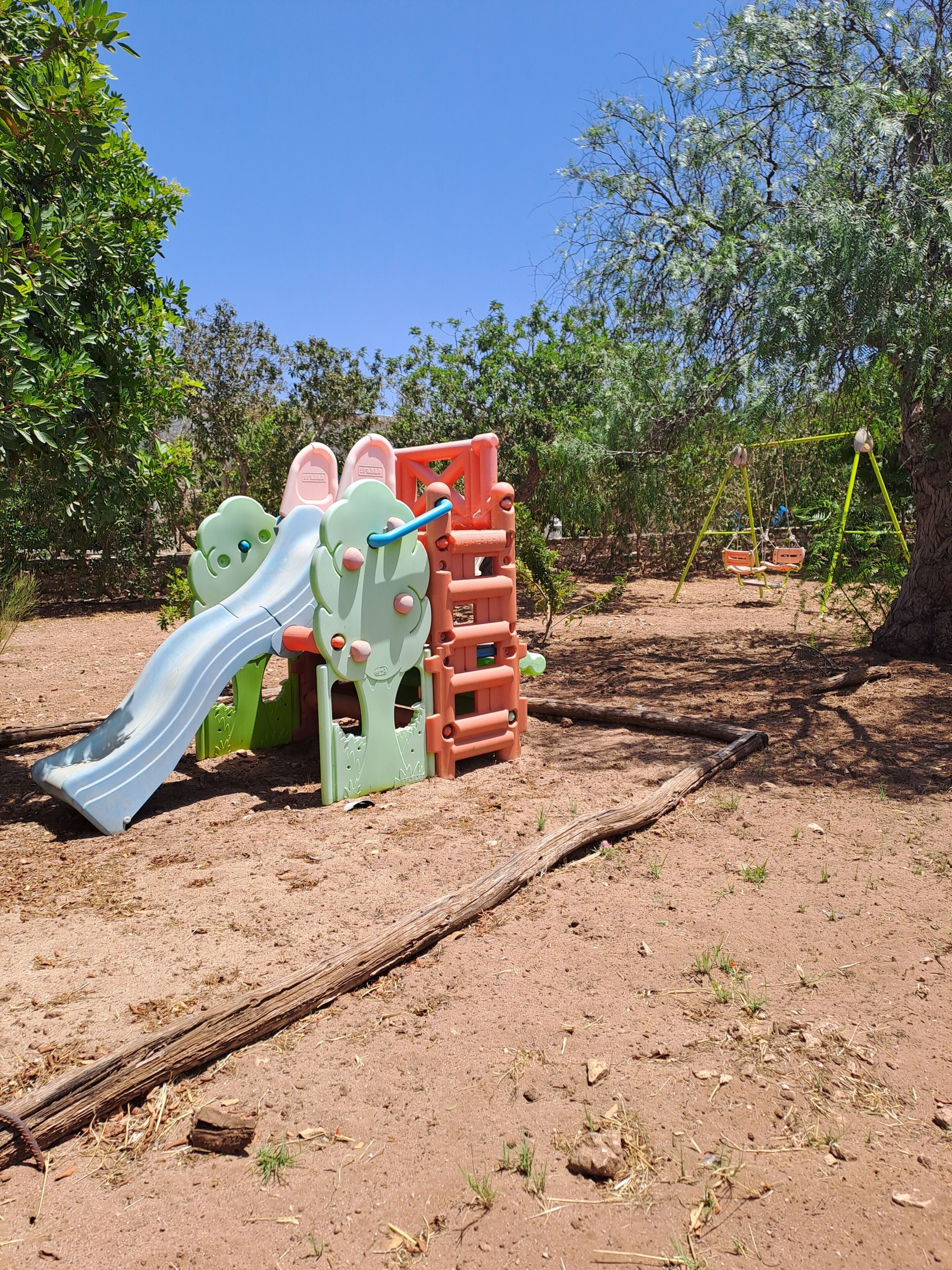 Ein Spielplatz mit Rutsche und Klettergeräten.
