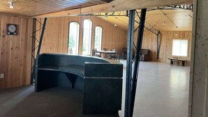 Et rummeligt værelse med en buet bænk, trævægge og store vinduer.