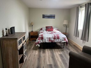 Ein Schlafzimmer mit Bett, Nachttischen, Schreibtisch und Stuhl.
