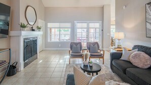 A spacious living room with a fireplace, two armchairs, a sofa, and a coffee table. - Scottsdale 4-bedroom house with pool and hot tub. (Scottsdale)