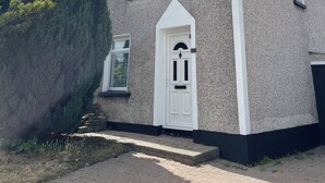 A two-story building with a white door and window, a chimney, and a sign reading 'PHOTO WATCHING.' - Serene 3-bedroom City Home in charming Kilkenny perfect for relaxing stays (Kilkenny)