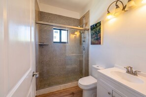 Een douche, handdoeken, zeep, toiletpapier