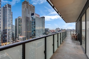 Uma varanda com vista para edifícios altos e o horizonte da cidade.
