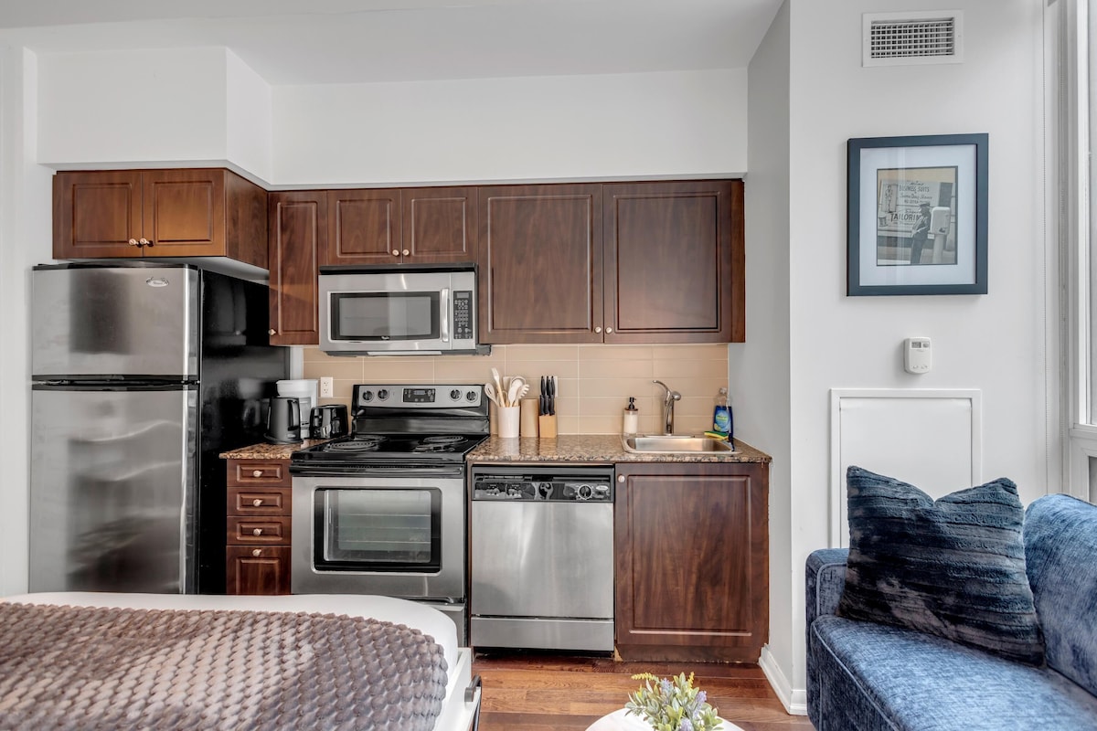 A modern kitchen with stainless steel appliances, wooden cabinets, and a built-in oven.