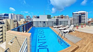 A rooftop pool with a clear view of the city skyline, surrounded by modern buildings. - Vacanze - Monteverdi (Maceió)