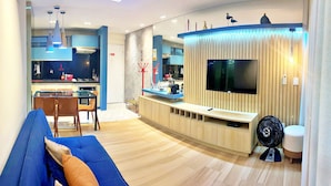 A modern living room with a TV, sofa, and dining area. - Vacanze - Monteverdi (Maceió)
