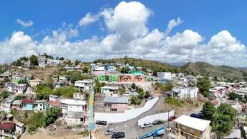 A panoramic view of a densely populated town with a prominent hill in the background.