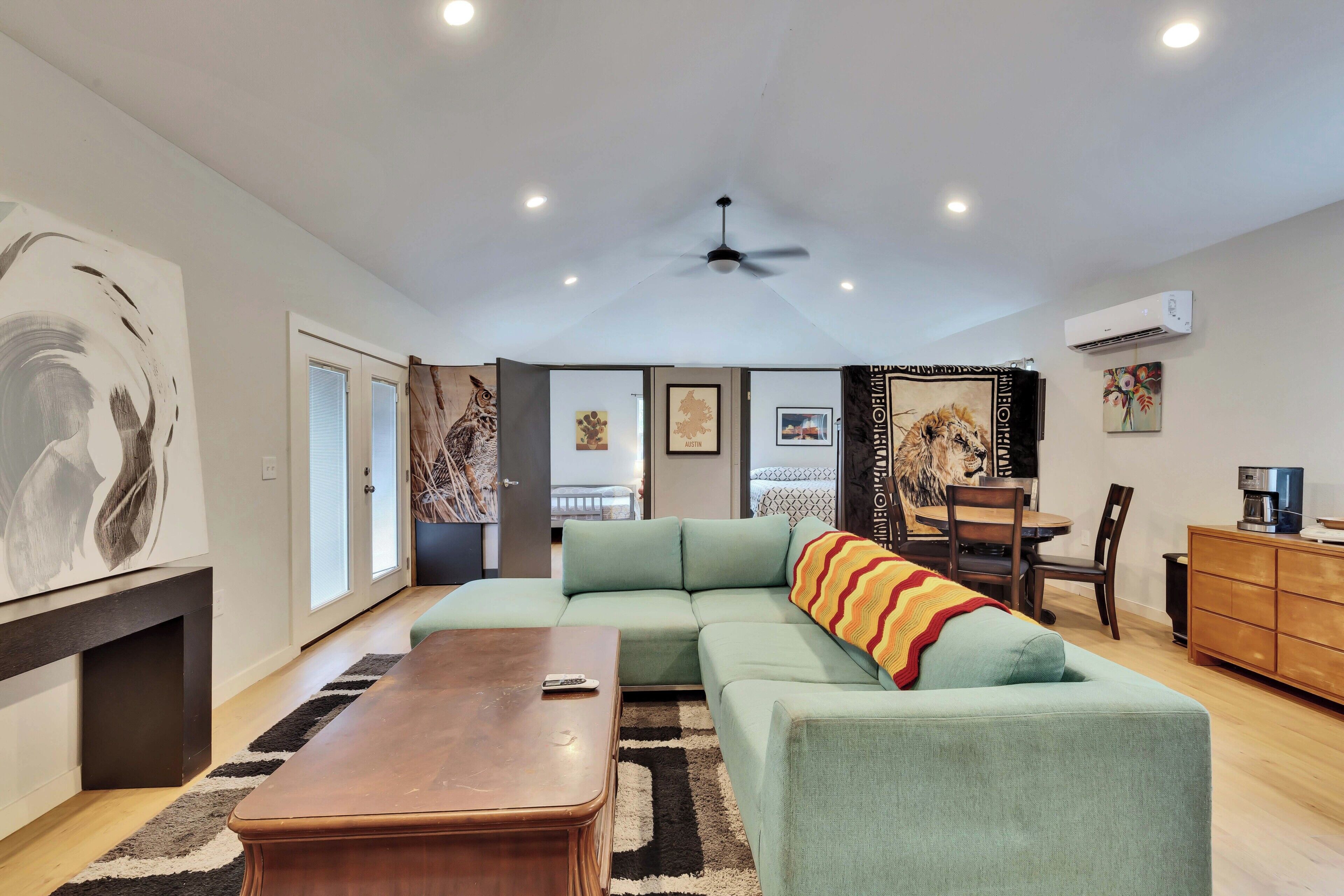 A modern living room with a sectional sofa, a wooden coffee table, and a ceiling fan.