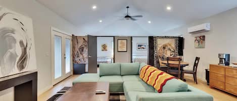 A modern living room with a sectional sofa, a wooden coffee table, and a ceiling fan.