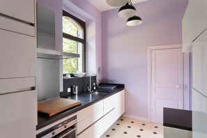 A modern kitchen with a large window, a black countertop, and a white door. - La chevreuse - Vue mer à moins de 300m de la plage (Lamballe)