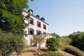 A large, two-story building with a prominent staircase, surrounded by dense greenery. - La chevreuse - Vue mer à moins de 300m de la plage (Lamballe)