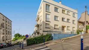 A multi-story building with balconies, a no parking sign, and a clear sky. - La Terrasse de la Rade - Terrasse avec vue mer (Brest)