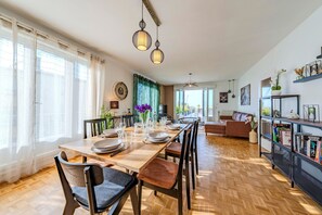 Ein Essbereich mit einem Holztisch, gedeckt für vier Personen, Stühlen und hängenden Pendelleuchten.
