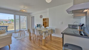 Eine moderne Küche mit Essbereich, Holzboden und Blick durch große Schiebetüren.