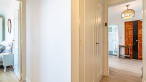 Ein Flur mit einer Tür, einem kleinen Tisch und einer Pendelleuchte.