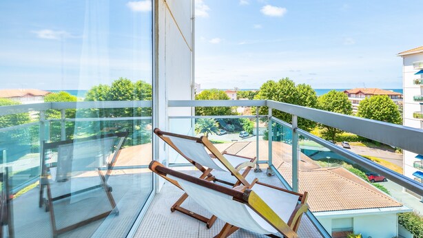 Ein Balkon mit Blick auf das Meer und die umliegenden Gebäude.
