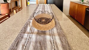 A modern kitchen with a central island, wooden cabinets, a stainless steel refrigerator, and a potted plant. - Casa Mamita | Spectacular ocean view | Terrace with private hot tub and pool (Puerto Escondido)