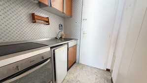 Eine kleine Küche mit Backofen, Geschirrspüler und Spüle.