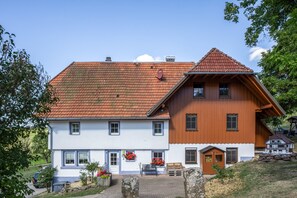 Ein zweistöckiges Gebäude mit rotem Ziegeldach, weißen Wänden und Holzelementen.