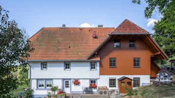 A two-story building with a red-tiled roof, white walls, and wooden accents.