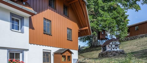 A two-story house with a sloped roof, wooden siding, and a small porch.