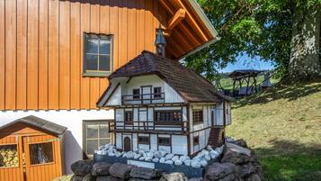 Uma casa modelo com estrutura de dois andares, varanda e base de pedra.