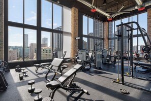 A gym with large windows, various exercise equipment, and a city view. - Steps to Marketplace • Near Cruise Terminal & Airport (Miami)