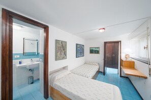 A bedroom with two beds, a bathroom with a sink, and a window with curtains. - Il Pulcino della Pavona - sea view and garden (Monterosso al Mare)