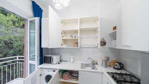 A compact kitchen with a washing machine, a microwave, and a gas stove. - Charlie 89 Modern Apt with A/C in the center (Monterosso al Mare)