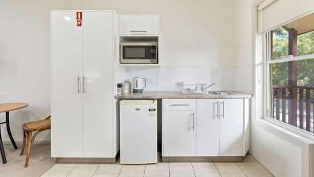 A compact kitchen with a microwave, a coffee maker, and a sink.