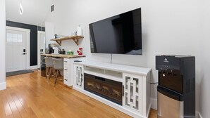 Een moderne keuken met een groot flatscreen-televisie, een ingebouwde open haard en een waterdispenser.
