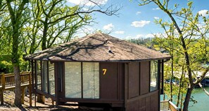 A wooden cabin with a peaked roof, large windows, and the number 7 on its side. - Canopy Seven: Tree Top - Pools - Pickleball - near Golf (Lake Ozark)