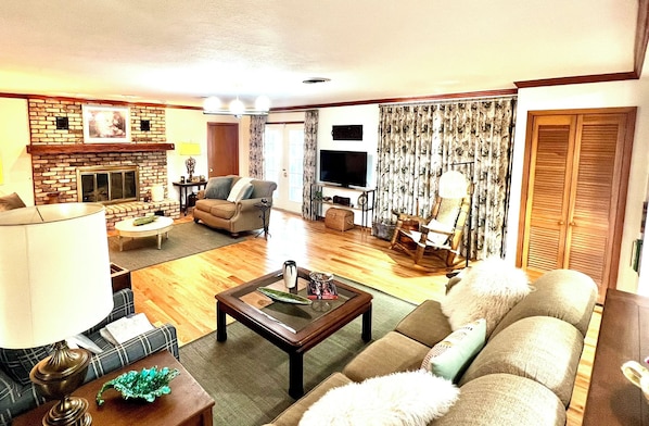 A living room with a fireplace, a television, and a sofa.