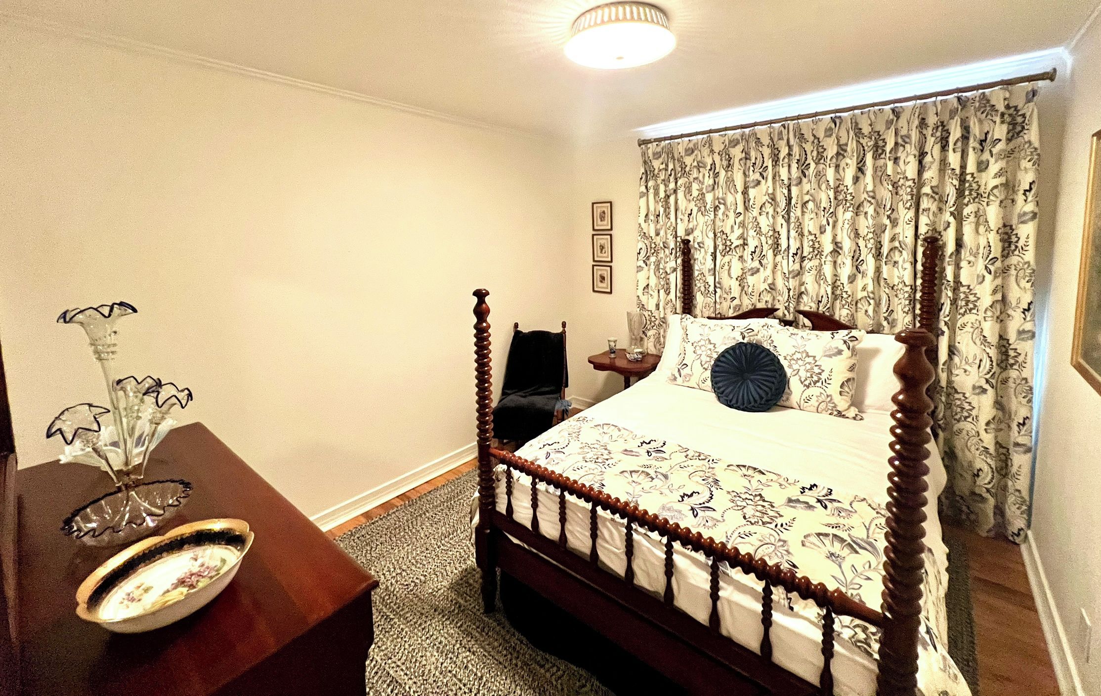 Una camera da letto con un letto a baldacchino, un comodino con un vaso e una tenda decorata.