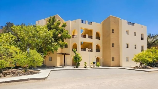 A multi-story building with a central courtyard, balconies, and greenery. - El Gouna luxury apartment lagoon and pool view (Red Sea Governorate)