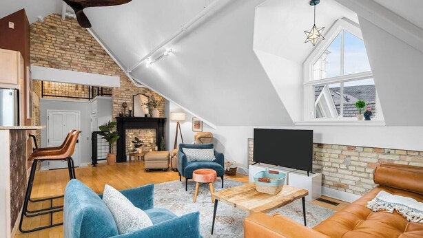 A loft-style living space with a kitchen, seating area, and a TV. - Cuckoo's Nest 3BR Traverse City condo (Traverse City)