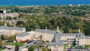 A large building complex with multiple towers, surrounded by lush greenery and a body of water in the background. - Cuckoo's Nest 3BR Traverse City condo (Traverse City)