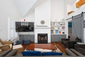 Ein Wohnzimmer mit Kamin, Fernseher und Sitzecke.