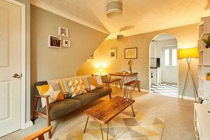 Ein Wohnzimmer mit Sofa, Couchtisch und Bücherregalen.
