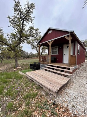 Eine rustikale Holzhütte mit einer Holzterrasse, einer Veranda und einer Tür mit der Nummer 3.