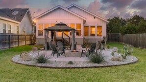 A residential backyard with a patio area, outdoor seating, and a fire pit. - Southern Hillcountry Hideaway (Canyon Lake)