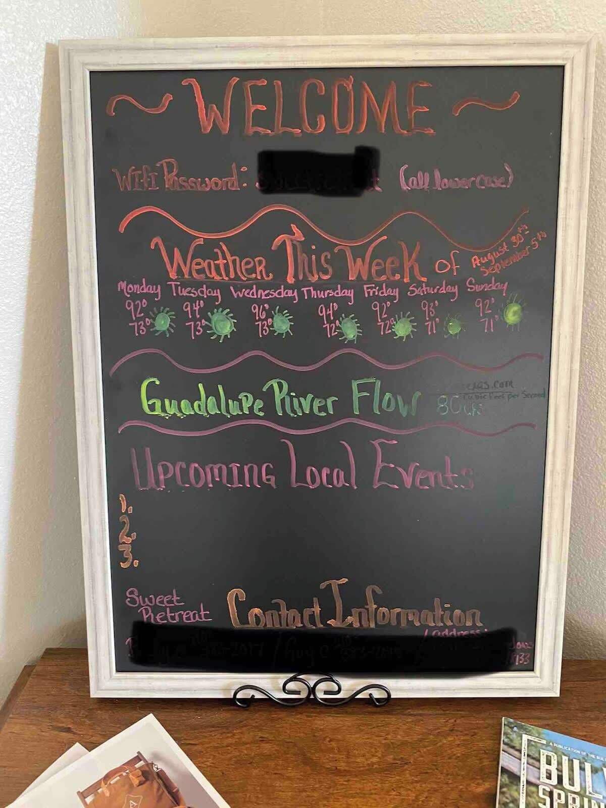A chalkboard with a welcome message, weekly weather forecast, and upcoming local events.