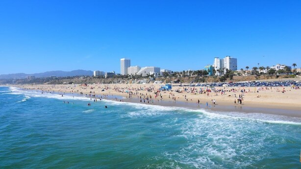 Una playa con un paisaje urbano al fondo.