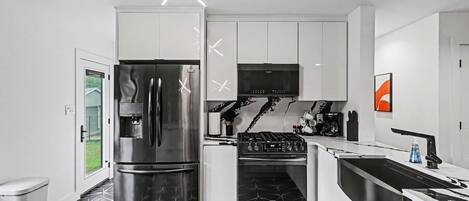Una cocina moderna con refrigerador, horno y estufa a gas incorporados.