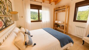 A bedroom with a bed, a window with a view, a wardrobe, and a radiator. - House with a Garden · Ribadesella · La Cuadra San Pedro (Ribadesella)