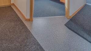 Ein Zimmer mit Bett, Tür und einem Vorhangfenster.