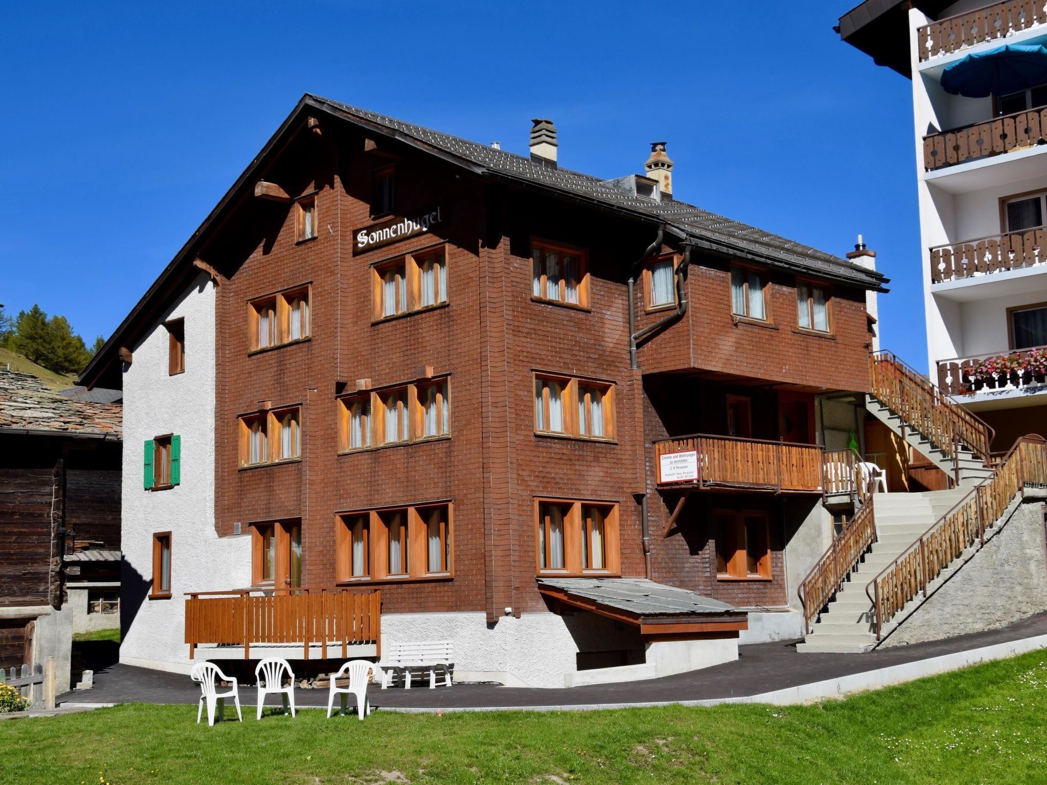 Un immeuble à plusieurs étages sur lequel on peut lire l’inscription « Sonnenhugel ».